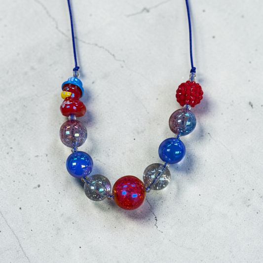 Mloved Designs red, white, and blue beaded statement necklace with novelty duck charm on a blue cord.