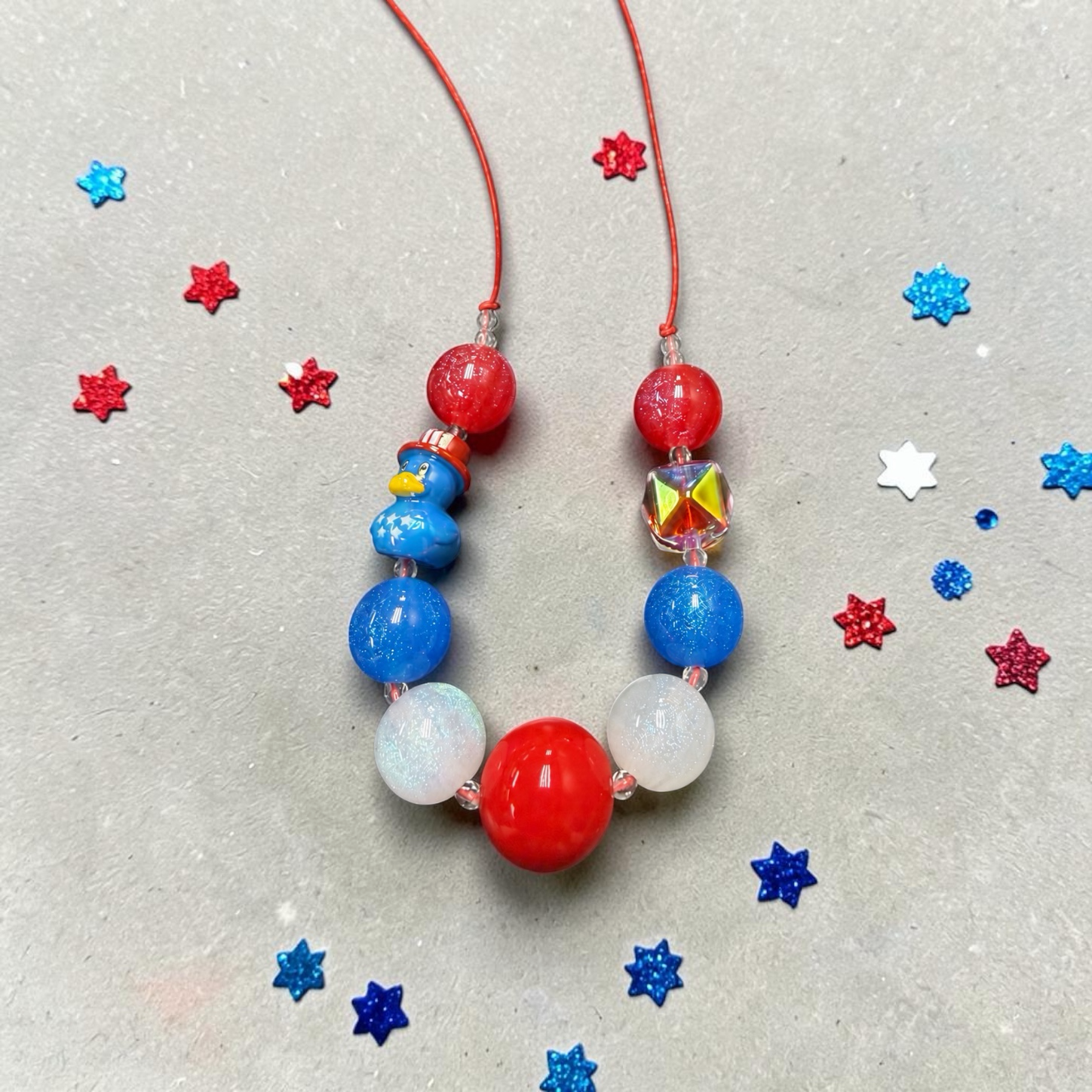 Mloved Designs patriotic beaded necklace with red, white, and blue glitter beads and a cute duck charm.